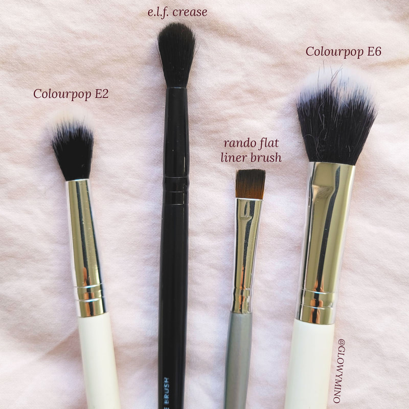 Flatlay of makeup brushes, left to right: Colourpop Tapered Blending Brush, e.l.f. Crease Brush, random flat liner brush, Colourpop Small Fluff Brush